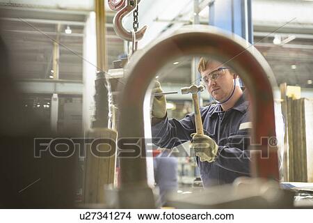 Picture - Apprentice learning machinery in factory. Fotosearch