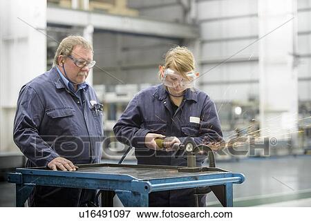 Apprentice learning machinery in factory View Large Photo Image Stock Photo - Apprentice learning machinery in factory. Fotosearch