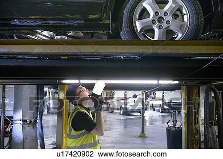 Apprentice working in car factory View Large Photo Image Stock Image - Apprentice working in car factory. Fotosearch
