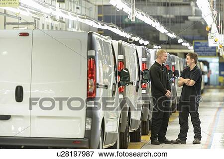 Stock Photo - Apprentices talking in car factory. Fotosearch