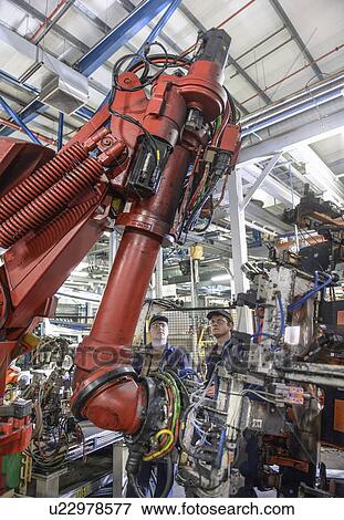 Stock Photo - Apprentices with robots in car factory. Fotosearch