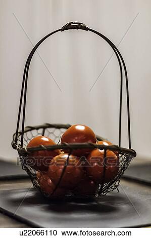 Stock Image - Basket of tomatoes on counter. Fotosearch