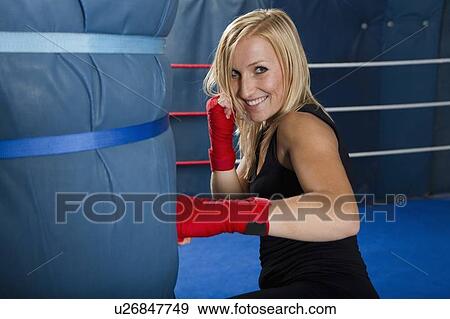 Stock Photo - Boxer training with punching bag. Fotosearch
