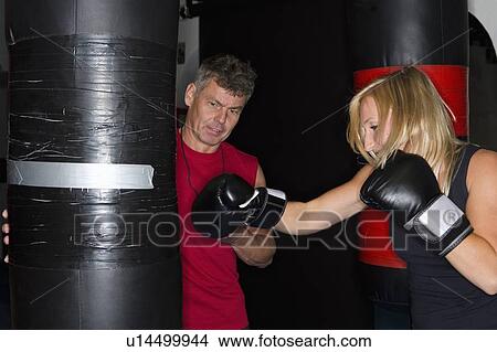 Picture - Boxer working with trainer in gym. Fotosearch