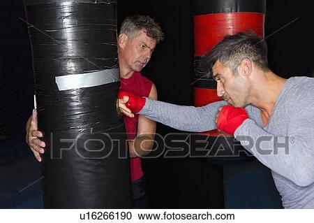 Boxer working with trainer in gym View Large Photo Image Stock Image - Boxer working with trainer in gym. Fotosearch