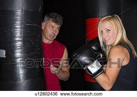 Stock Photograph - Boxer working with trainer in gym. Fotosearch