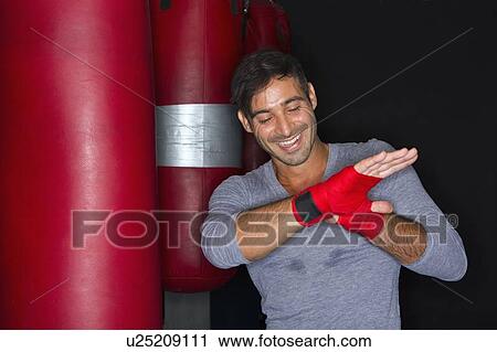 Stock Image - Boxer wrapping his hands in gym. Fotosearch