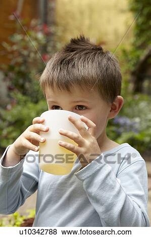Boy drinking juice in garden View Large Photo Image Stock Photo - Boy drinking juice in garden. Fotosearch