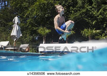 Stock Photograph - Boy jumping into swimming pool. Fotosearch