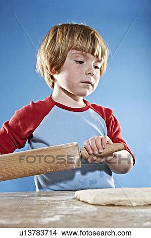 Picture - Boy rolling out dough. Fotosearch