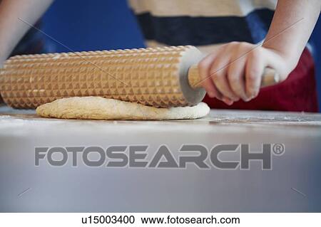 Boy rolling out dough with studded pin View Large Photo Image Stock Image - Boy rolling out dough with studded pin. Fotosearch