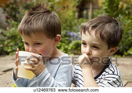 Stock Image - Boys relaxing in garden. Fotosearch