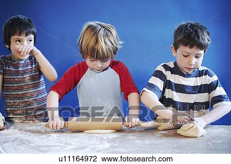 Boys rolling out dough with pins View Large Photo Image Stock Image - Boys rolling out dough with pins. Fotosearch