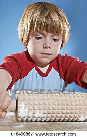 Boys rolling out dough with studded pin View Large Photo Image Stock Photo - Boys rolling out dough with studded pin. Fotosearch