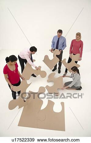 Business people assembling puzzle View Large Photo Image Stock Photo - Business people assembling puzzle. Fotosearch
