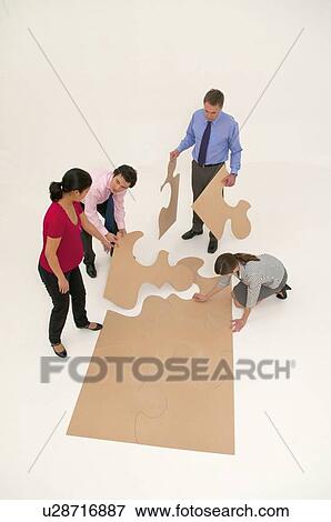 Business people assembling puzzle View Large Photo Image Stock Photo - Business people assembling puzzle. Fotosearch