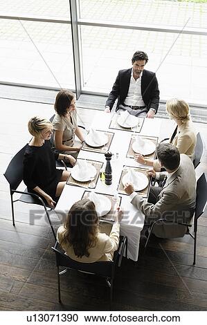Stock Image - Business people having lunch together. Fotosearch