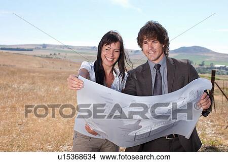 Picture - Business people reading blueprints. Fotosearch