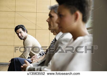 Stock Image - Business people sitting by window. Fotosearch