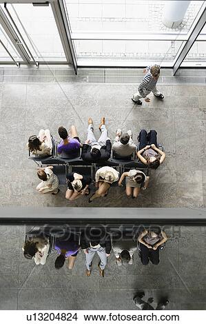 Picture - Business people sitting in waiting area. Fotosearch