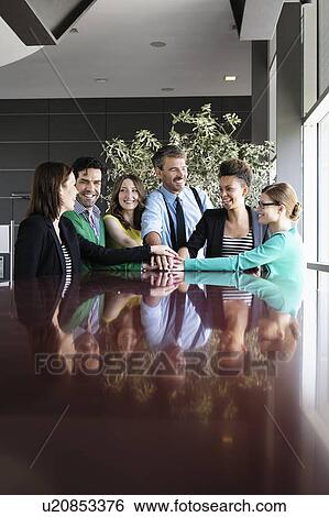 Stock Photograph - Business people smiling at table. Fotosearch