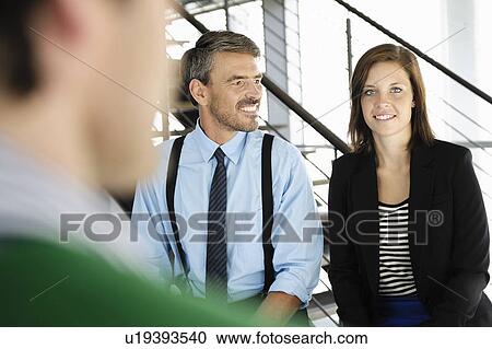 Business people standing in office View Large Photo Image Stock Image - Business people standing in office. Fotosearch