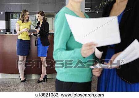 Stock Image - Business people talking in office. Fotosearch