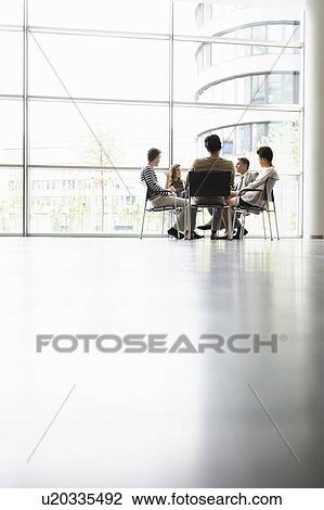 Stock Image - Business people talking in office. Fotosearch