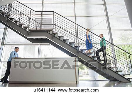 Picture - Business people walking in office. Fotosearch