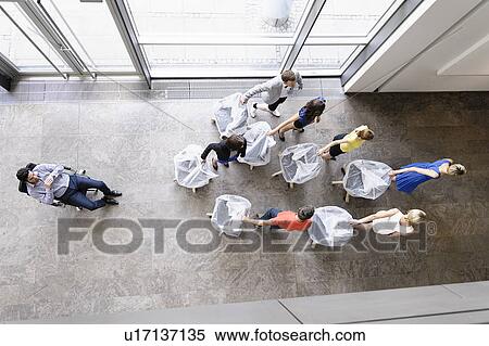 Stock Photography - Business people with new office chairs. Fotosearch