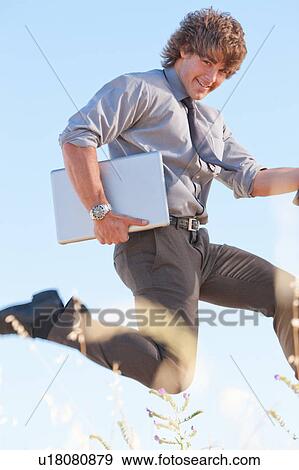 Businessman carrying laptop outdoors View Large Photo Image Stock Photo - Businessman carrying laptop outdoors. Fotosearch