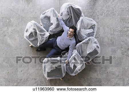 Businessman sitting in new office chair View Large Photo Image Stock Image - Businessman sitting in new office chair. Fotosearch