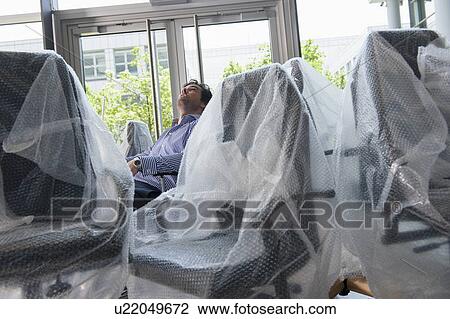 Businessman sitting in new office chair View Large Photo Image Stock Image - Businessman sitting in new office chair. Fotosearch