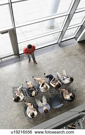 Stock Photograph - Businessman speaking to colleagues. Fotosearch