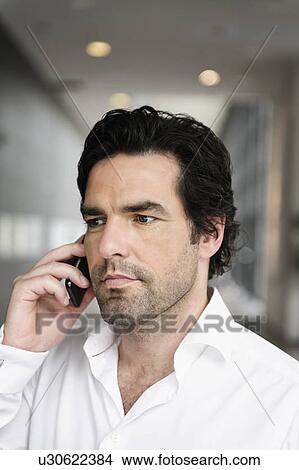 Businessman talking on cell phone View Large Photo Image Picture - Businessman talking on cell phone. Fotosearch