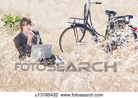 Businessman working in tall grass View Large Photo Image Stock Image - Businessman working in tall grass. Fotosearch