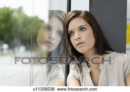 Businesswoman leaning against window View Large Photo Image Stock Photo - Businesswoman leaning against window. Fotosearch