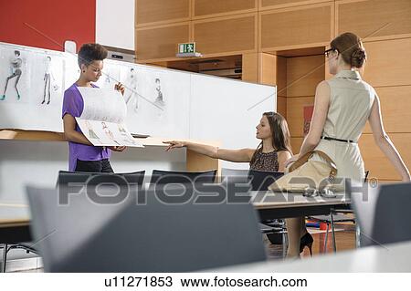 Stock Image - Businesswomen talking in office. Fotosearch