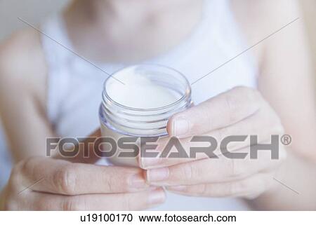Close up of girl holding pot of lotion View Large Photo Image Stock Image - Close up of girl holding pot of lotion. Fotosearch
