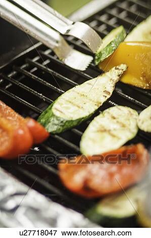 Close up of vegetables cooking on grill View Large Photo Image Stock Photo - Close up of vegetables cooking on grill. Fotosearch