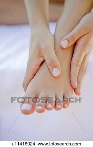 Picture - Close up of woman rubbing her foot. Fotosearch
