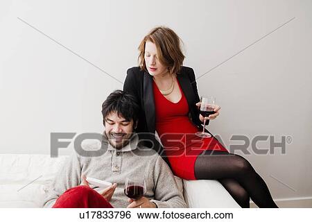 Couple drinking wine on sofa View Large Photo Image Stock Photograph - Couple drinking wine on sofa. Fotosearch