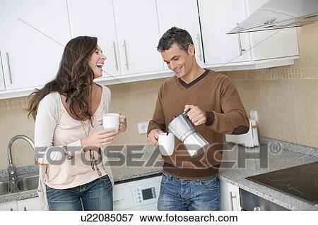 Couple having coffee in kitchen View Large Photo Image Stock Photo - Couple having coffee in kitchen. Fotosearch