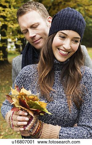 Stock Image - Couple holding autumn leaves. Fotosearch