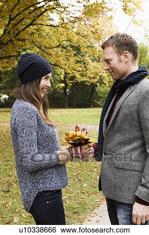 Stock Photograph - Couple holding autumn leaves. Fotosearch