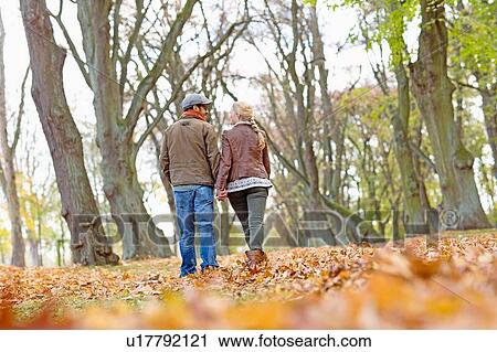 Stock Image - Couple holding hands in forest. Fotosearch