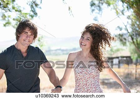 Stock Image - Couple holding hands outdoors. Fotosearch