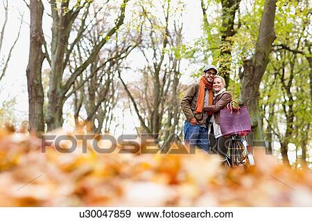 Couple hugging by bicycle in forest View Large Photo Image Stock Photo - Couple hugging by bicycle in forest. Fotosearch