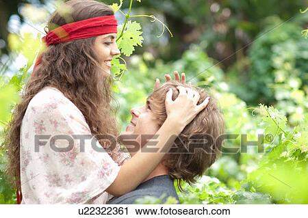 Stock Image - Couple hugging in tall plants. Fotosearch