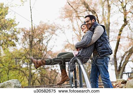 Couple hugging over park railing View Large Photo Image Stock Photography - Couple hugging over park railing. Fotosearch